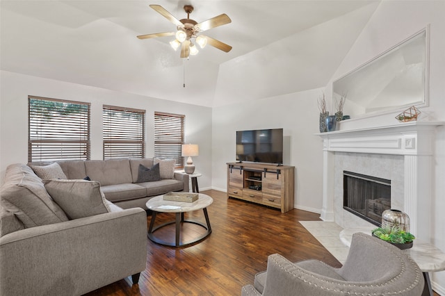 living room featuring ceiling fan, lofted ceiling, dark wood-type flooring, and a tile fireplace