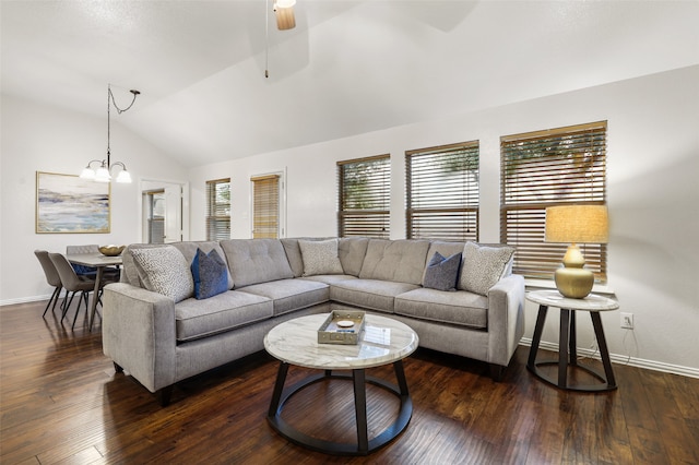 living room featuring ceiling fan with notable chandelier, dark wood-type flooring, and vaulted ceiling