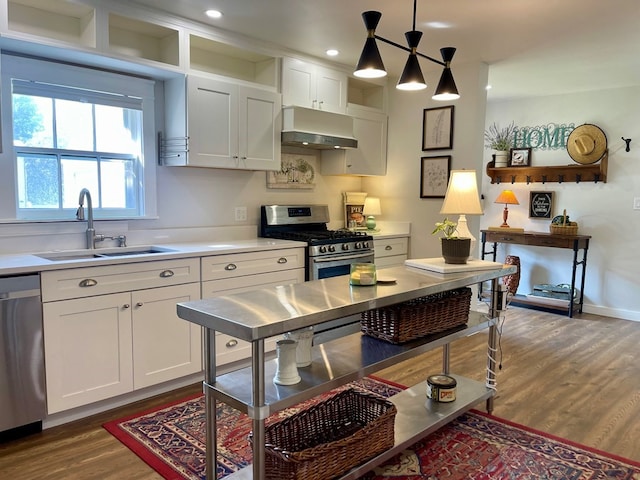 kitchen with stainless steel appliances, hanging light fixtures, dark hardwood / wood-style flooring, and white cabinetry