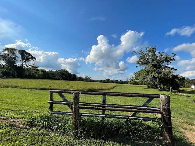 view of gate featuring a yard and a rural view