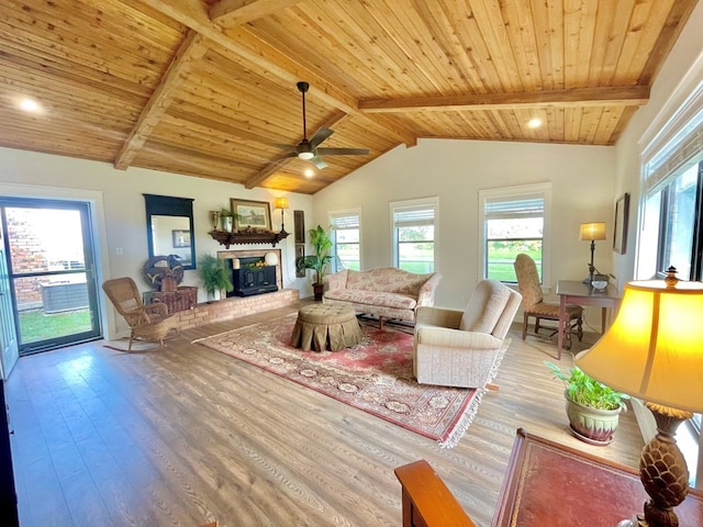 living room featuring a brick fireplace, vaulted ceiling with beams, hardwood / wood-style flooring, and ceiling fan