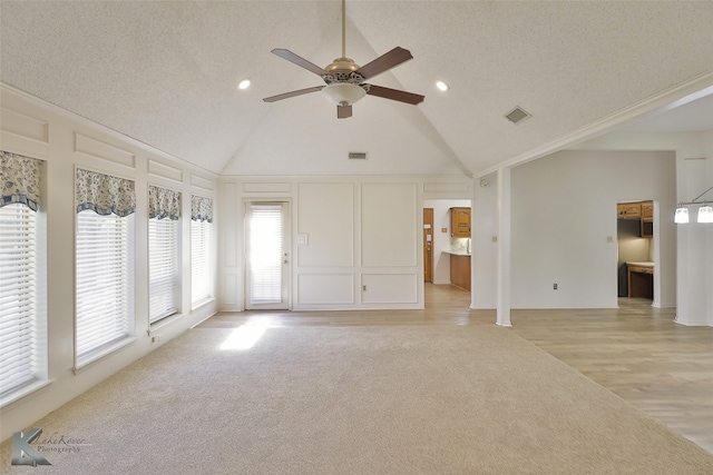 unfurnished living room with high vaulted ceiling, light hardwood / wood-style floors, a textured ceiling, and ceiling fan