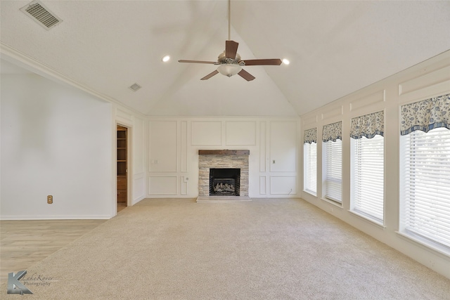 unfurnished living room with ceiling fan, light carpet, a healthy amount of sunlight, and a fireplace