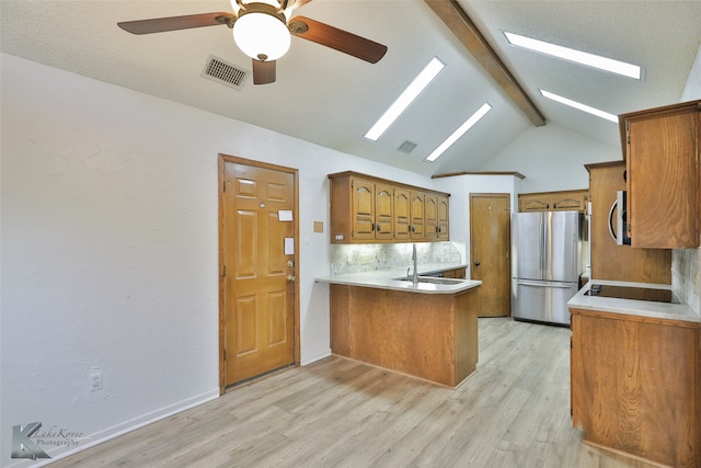 kitchen with light hardwood / wood-style floors, kitchen peninsula, appliances with stainless steel finishes, ceiling fan, and vaulted ceiling with beams