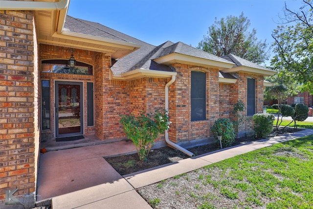 view of exterior entry featuring a yard