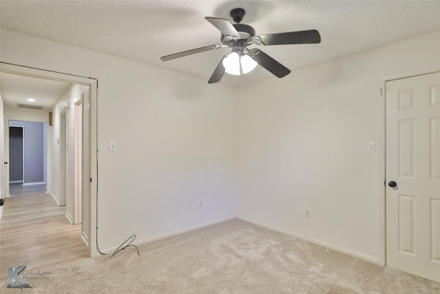 carpeted spare room with ceiling fan and a textured ceiling