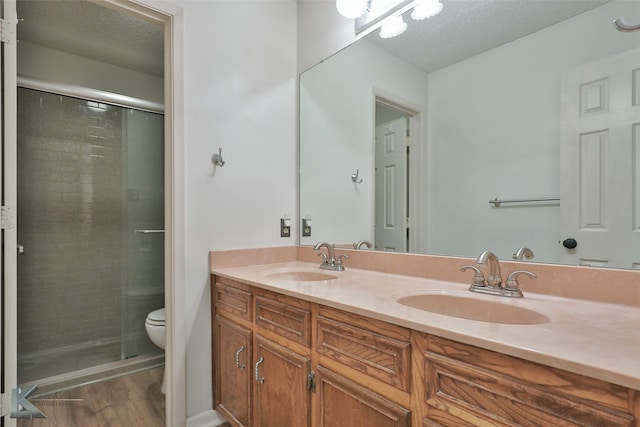 bathroom with vanity, hardwood / wood-style flooring, a textured ceiling, and toilet