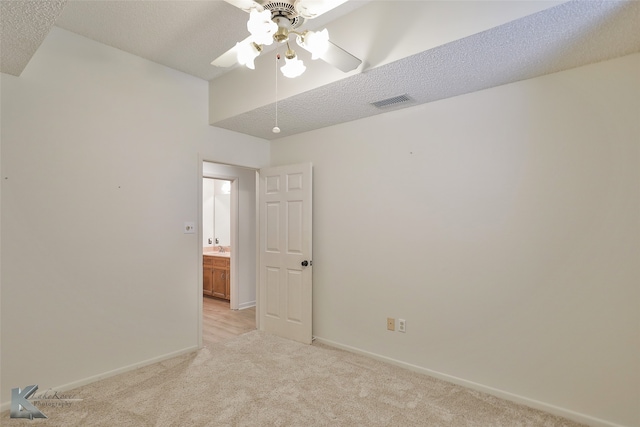 carpeted spare room with ceiling fan and a textured ceiling