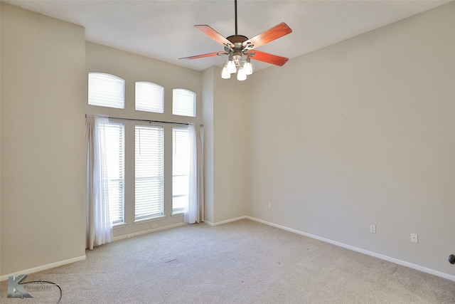 empty room featuring light colored carpet, a healthy amount of sunlight, and ceiling fan