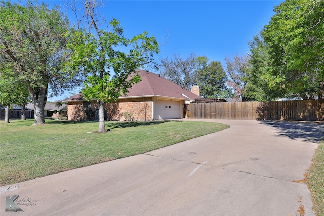 view of side of home featuring a garage and a yard