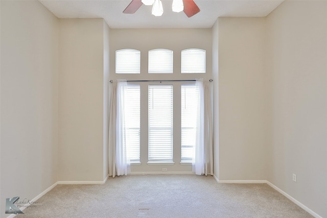 spare room featuring ceiling fan, a healthy amount of sunlight, and light carpet