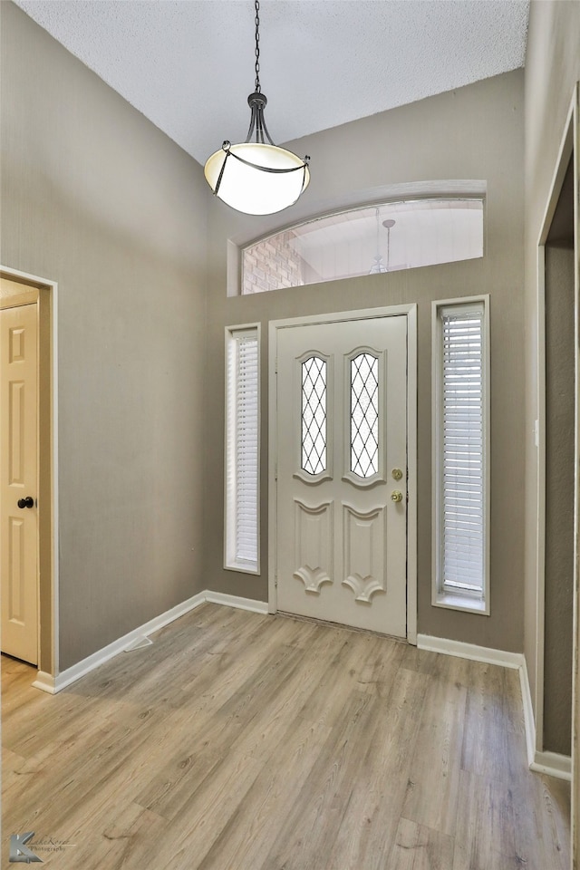 entryway featuring light wood-type flooring and a textured ceiling