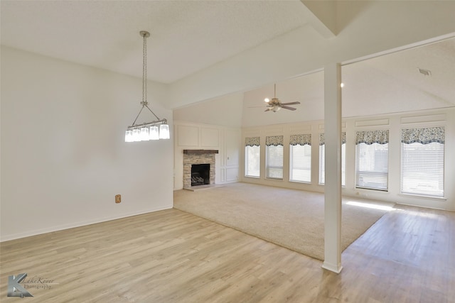 unfurnished living room featuring a fireplace, light hardwood / wood-style floors, ceiling fan, and high vaulted ceiling