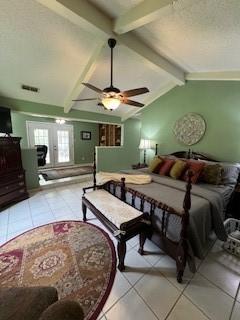 bedroom featuring vaulted ceiling with beams, ceiling fan, french doors, and light tile patterned flooring