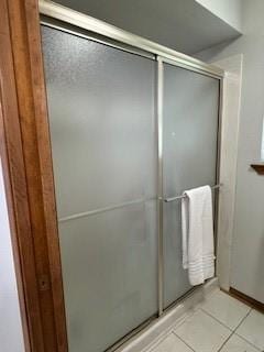 bathroom with tile patterned floors and a shower with shower door