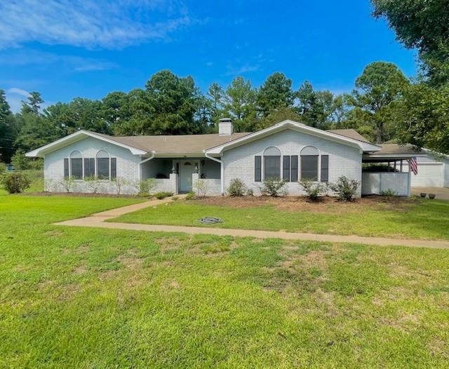 single story home with a carport and a front lawn