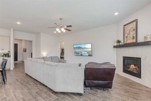 living room featuring a fireplace, hardwood / wood-style floors, and ceiling fan