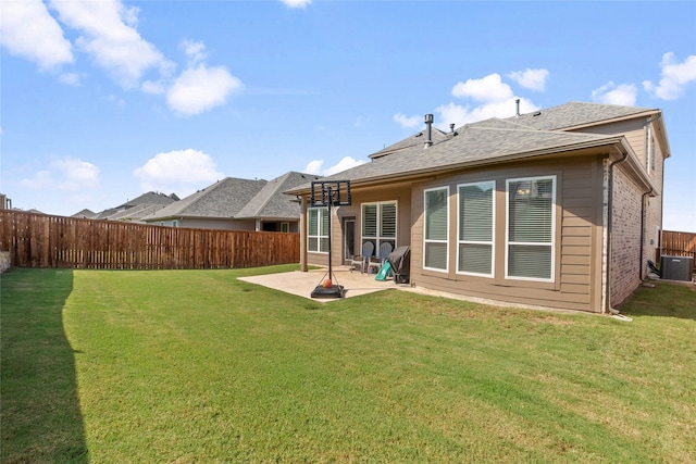 back of property with a patio, a yard, and central AC