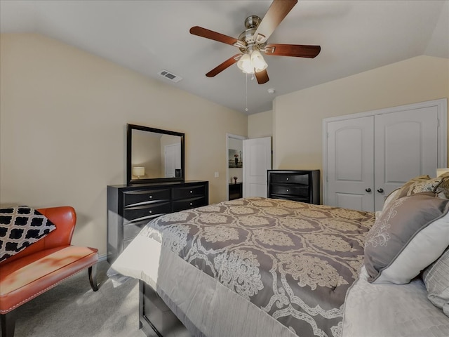 carpeted bedroom with ceiling fan, a closet, and vaulted ceiling