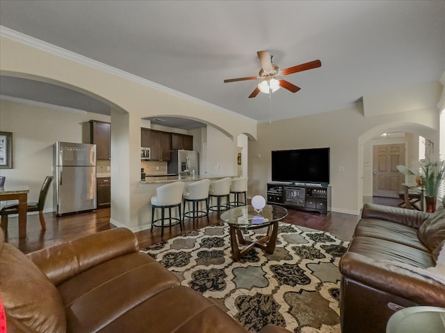 living room featuring crown molding, ceiling fan, and dark wood-type flooring