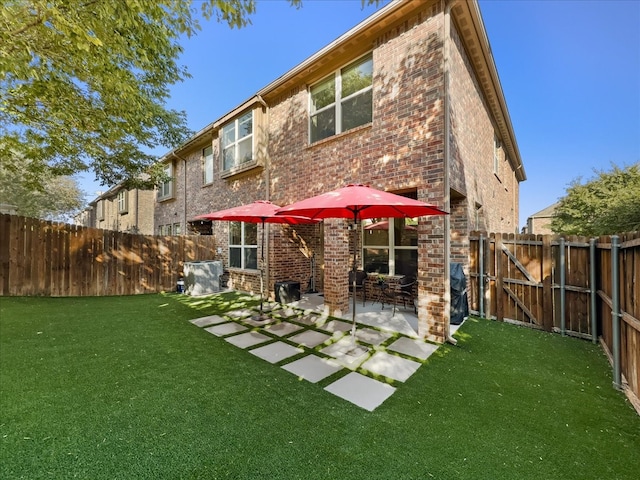 back of house featuring a yard and a patio