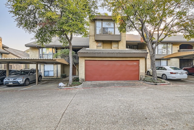 view of front of house with a carport, a balcony, and a garage