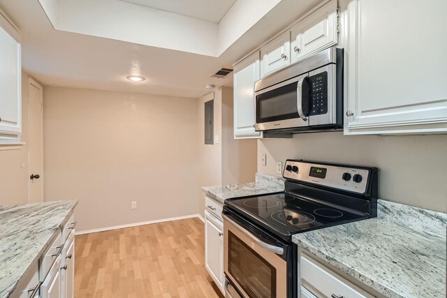 kitchen with light stone counters, stainless steel appliances, light wood-type flooring, and white cabinetry