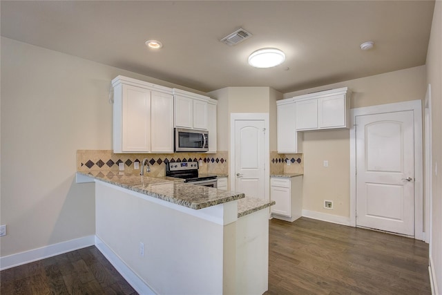 kitchen featuring white cabinets, stainless steel appliances, dark wood-type flooring, and tasteful backsplash