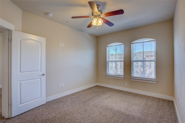 carpeted spare room with ceiling fan