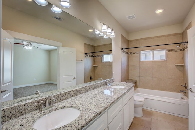 full bathroom featuring ceiling fan, vanity, tiled shower / bath combo, tile patterned flooring, and toilet