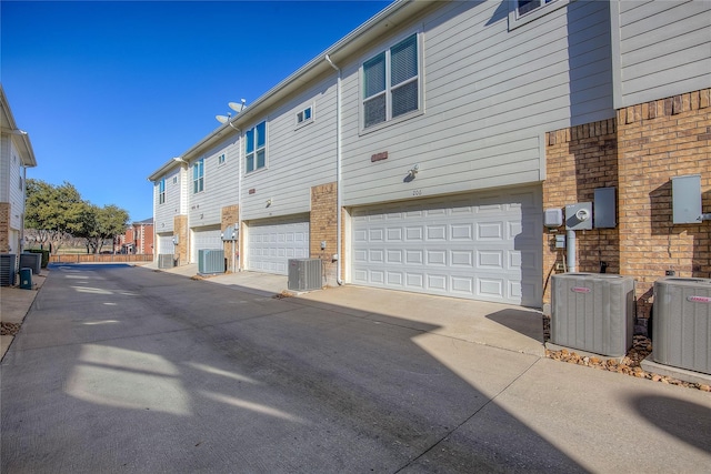 exterior space with a garage and cooling unit