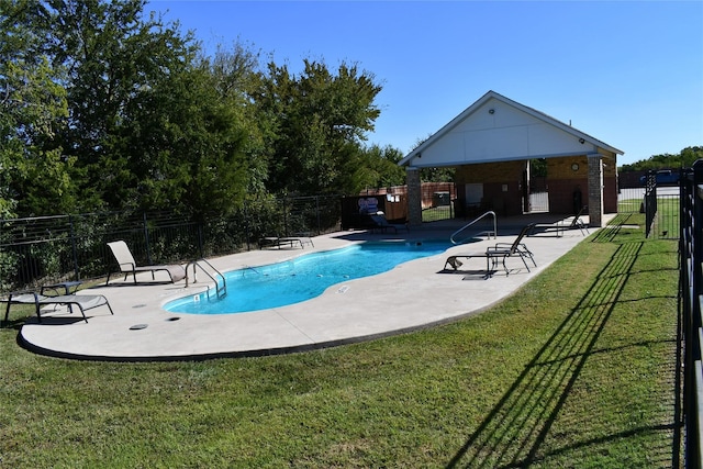 view of pool with a patio and a lawn