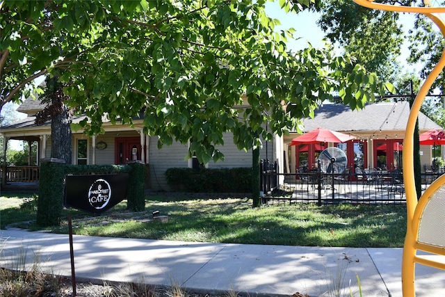 view of property hidden behind natural elements featuring a front lawn