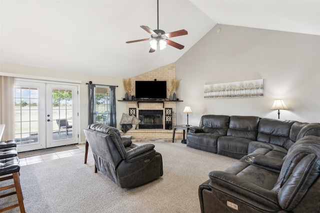 carpeted living room with a brick fireplace, high vaulted ceiling, ceiling fan, and french doors