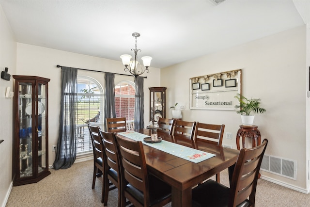 carpeted dining space featuring a chandelier