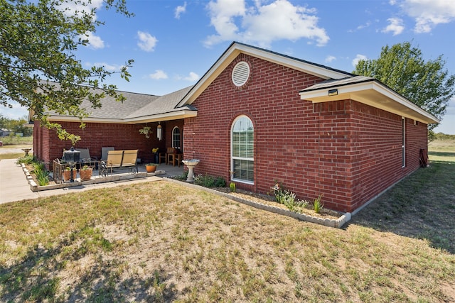 view of home's exterior with a yard and a patio area