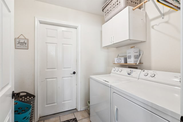 clothes washing area with cabinets, washing machine and clothes dryer, and light tile patterned flooring