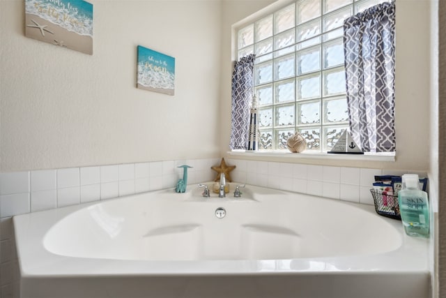 bathroom with a bathtub and a healthy amount of sunlight