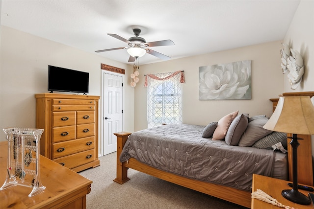 bedroom featuring a closet, light colored carpet, and ceiling fan