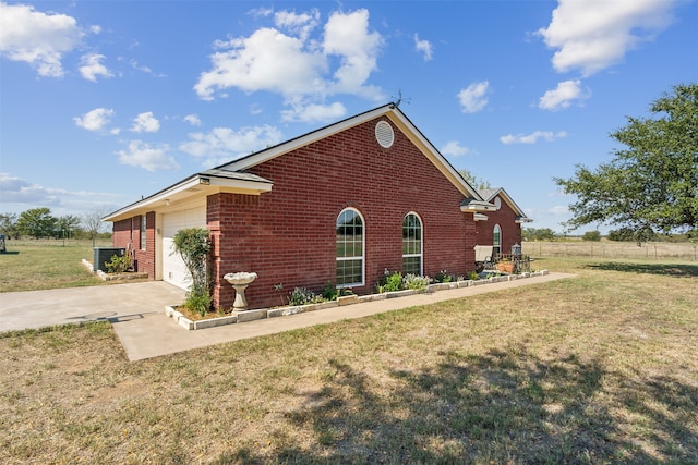 view of side of property featuring a garage and a yard