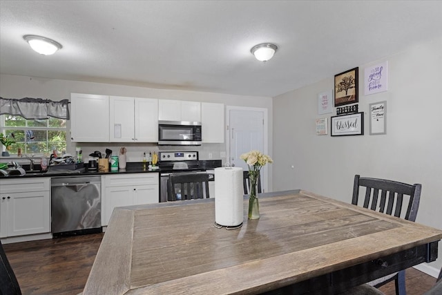 kitchen with dark hardwood / wood-style floors, sink, white cabinetry, appliances with stainless steel finishes, and a textured ceiling