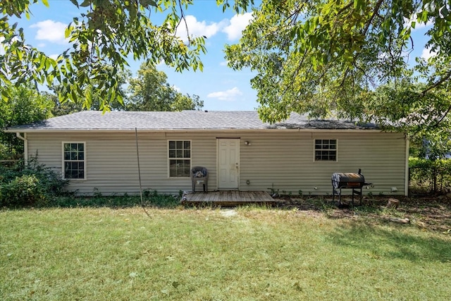 rear view of house with a deck and a lawn