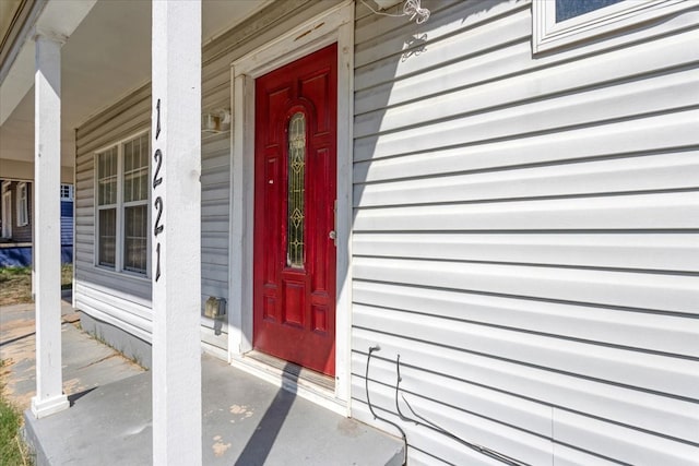 view of exterior entry featuring covered porch