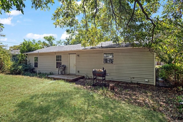 rear view of house with a deck and a yard