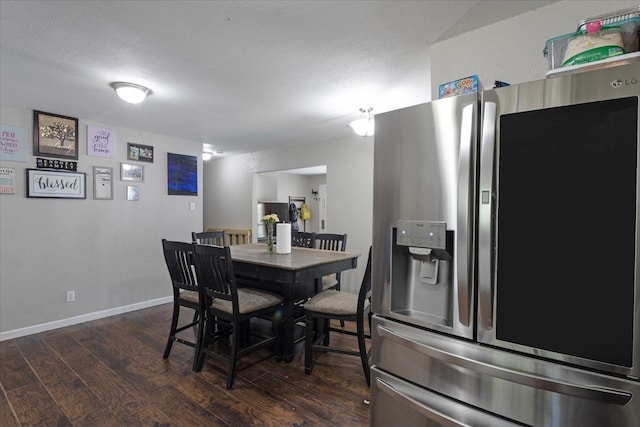 dining space with dark wood-type flooring and a textured ceiling