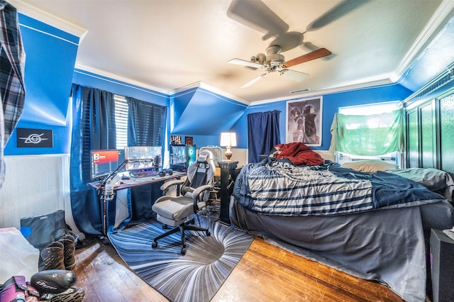 bedroom with lofted ceiling, ornamental molding, hardwood / wood-style flooring, and ceiling fan