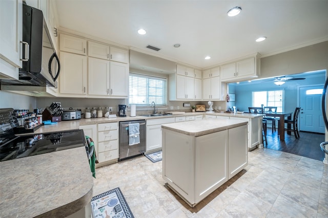 kitchen with white cabinets, stainless steel appliances, plenty of natural light, and a kitchen island