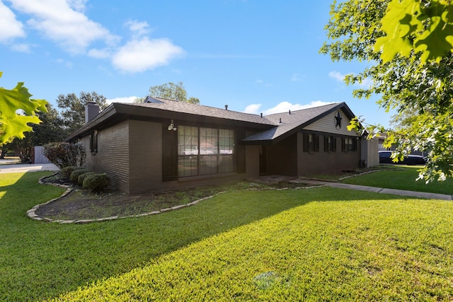 rear view of property with a yard