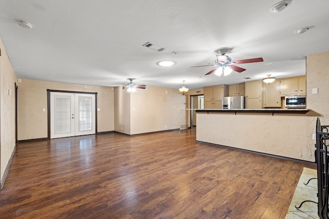 kitchen with appliances with stainless steel finishes, dark wood-type flooring, light brown cabinets, and ceiling fan with notable chandelier