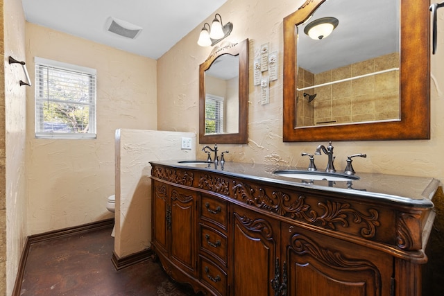 bathroom with vanity, toilet, and a shower